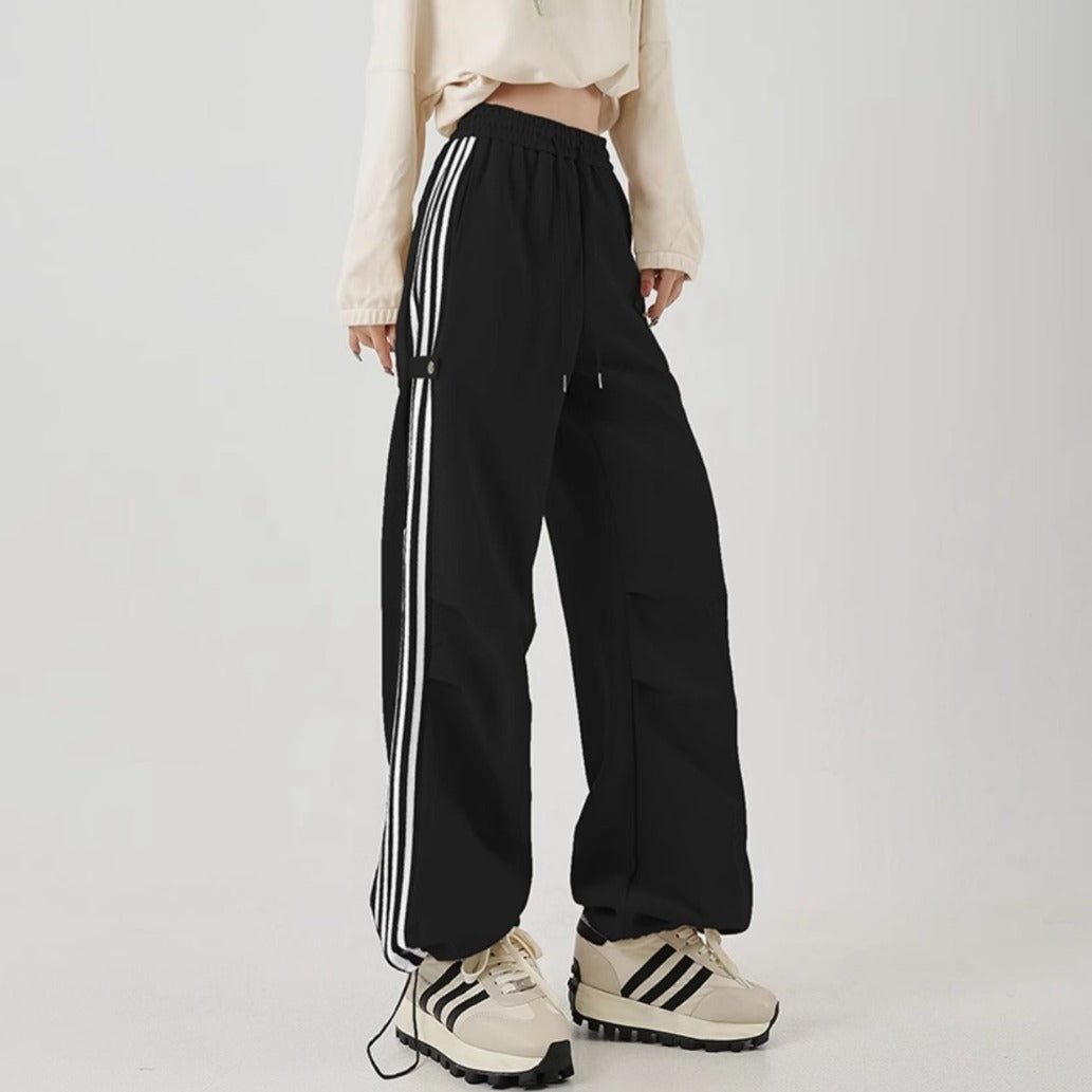 Wide-leg black cotton sweatpants with side stripes, perfect for summer workwear and casual outfits.